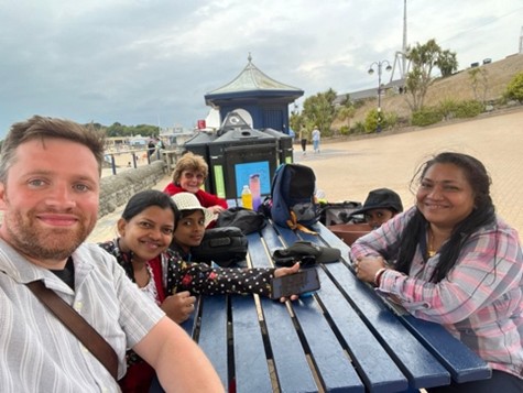 Members of Weoly Castle sitting around a picnic table. 